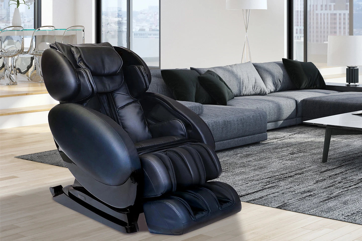 Infinity IT-8500 Plus black massage chair displayed in a modern living room in a relaxed Zero Gravity position