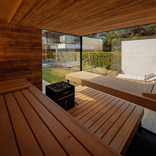 Interior view of ThermaSol Ombra outdoor sauna featuring thermo-aspen benches, panoramic glass walls, and luxury backyard wellness design