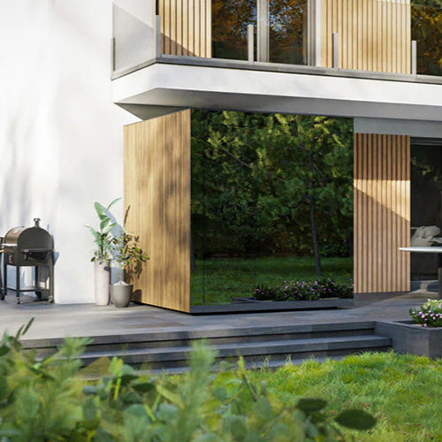 ThermaSol Spectra modern outdoor sauna cabin with glass corner design beside luxury home